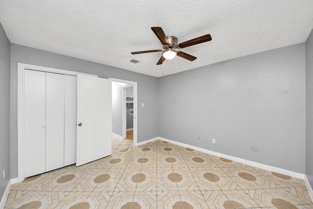 unfurnished bedroom with ceiling fan, a textured ceiling, and a closet