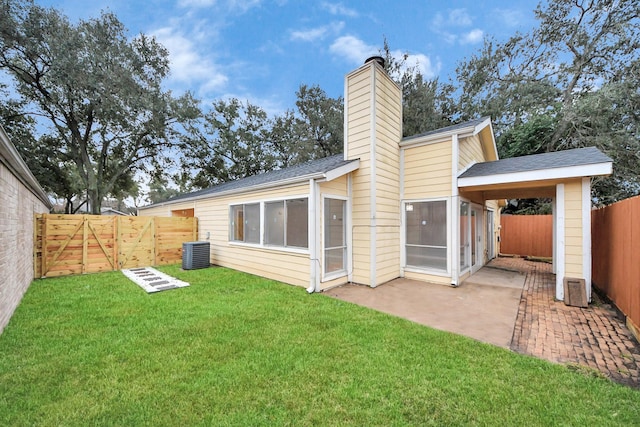 back of property with a patio area, central air condition unit, and a lawn