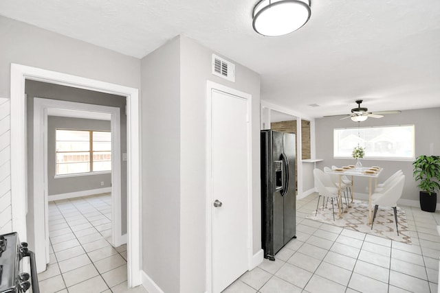 kitchen featuring ceiling fan, black refrigerator with ice dispenser, a textured ceiling, and light tile patterned floors