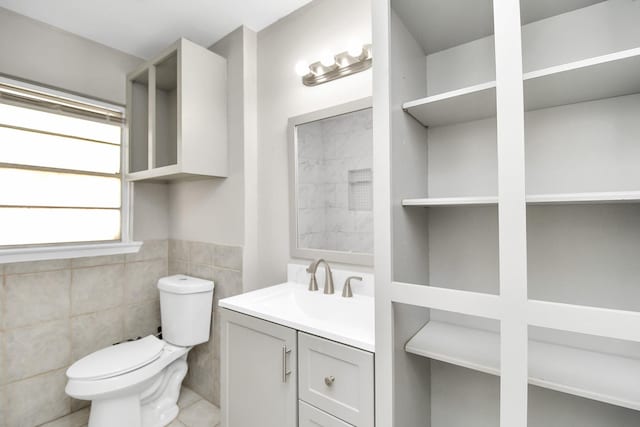 bathroom with tile walls, vanity, and toilet