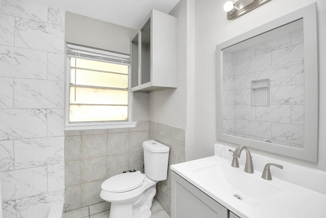 bathroom with vanity, tile walls, and toilet