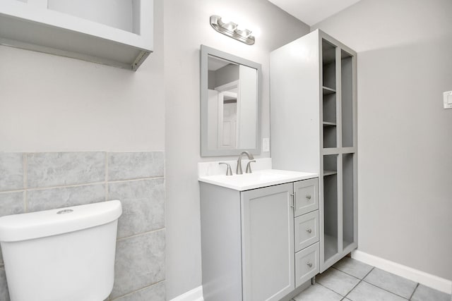 bathroom with tile patterned flooring, vanity, tile walls, and toilet