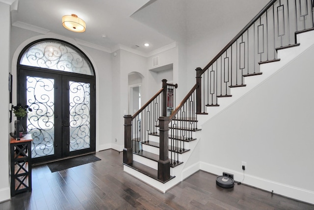 foyer featuring ornamental molding, dark hardwood / wood-style flooring, and french doors