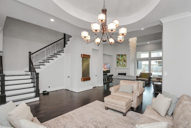 living room featuring a raised ceiling, hardwood / wood-style floors, and a notable chandelier