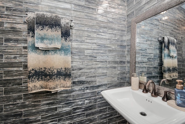 bathroom featuring sink and tile walls