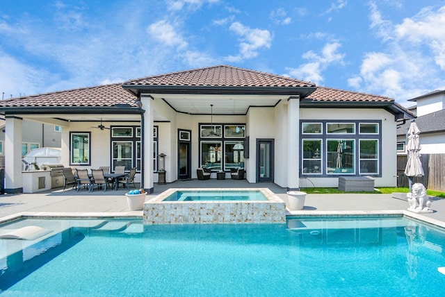 rear view of house featuring ceiling fan, a swimming pool with hot tub, exterior kitchen, and a patio