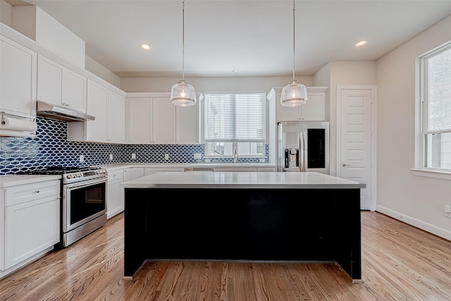 kitchen featuring pendant lighting, white cabinets, and appliances with stainless steel finishes