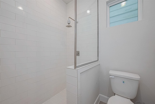 bathroom featuring toilet and a tile shower