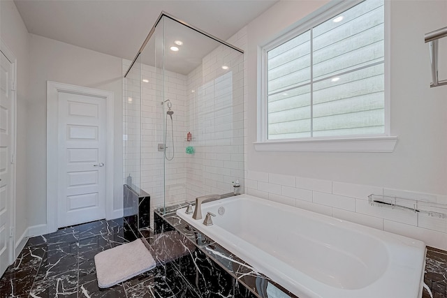 bathroom featuring shower with separate bathtub