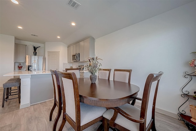 dining area with sink and light hardwood / wood-style flooring