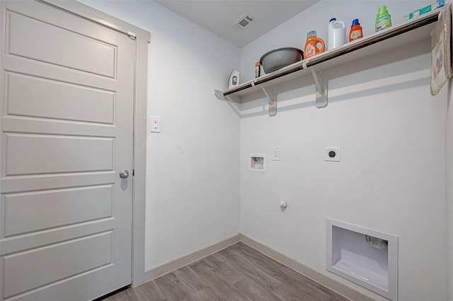 laundry area featuring gas dryer hookup, hookup for a washing machine, light hardwood / wood-style flooring, and electric dryer hookup