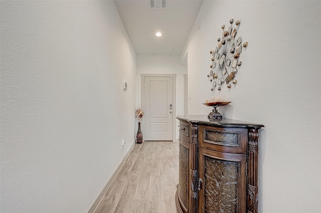 corridor with light hardwood / wood-style floors