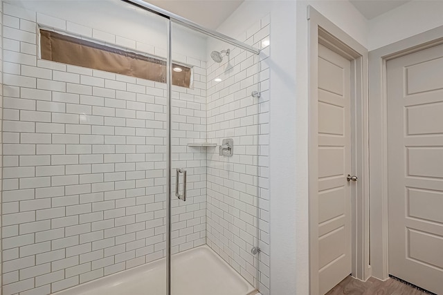 bathroom with a shower with door