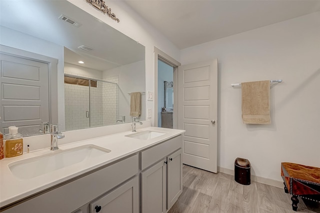 bathroom with vanity, hardwood / wood-style flooring, and walk in shower