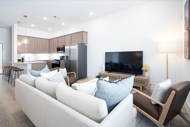 living room with sink and light hardwood / wood-style flooring