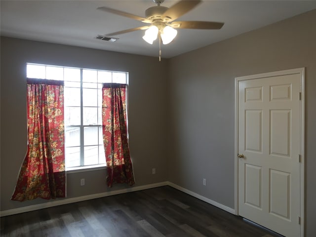 spare room featuring ceiling fan, plenty of natural light, and dark hardwood / wood-style flooring