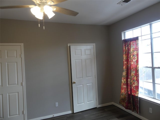 spare room with dark wood-type flooring and ceiling fan