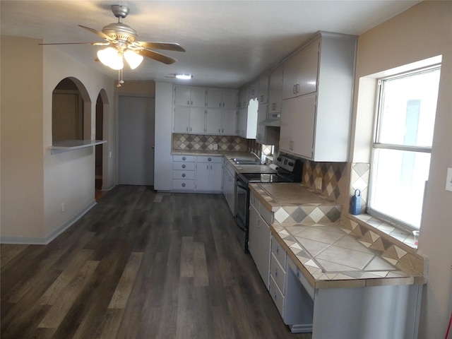 kitchen featuring tasteful backsplash, sink, dark hardwood / wood-style flooring, tile counters, and electric range