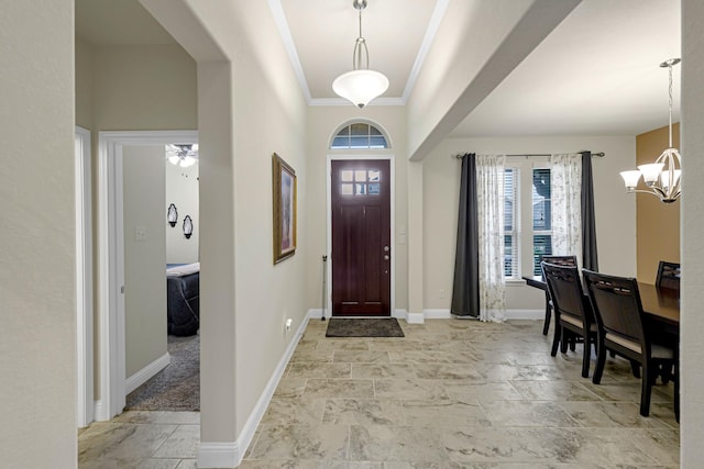 foyer featuring crown molding and a chandelier