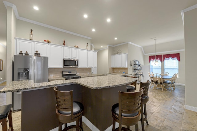 kitchen featuring appliances with stainless steel finishes, decorative light fixtures, light stone countertops, and white cabinets