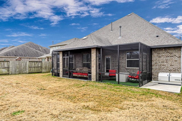 rear view of property featuring a patio, a sunroom, and a lawn