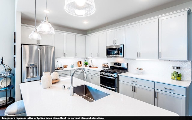 kitchen with pendant lighting, sink, white cabinetry, backsplash, and stainless steel appliances