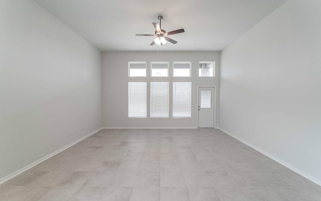 empty room with baseboards and a ceiling fan