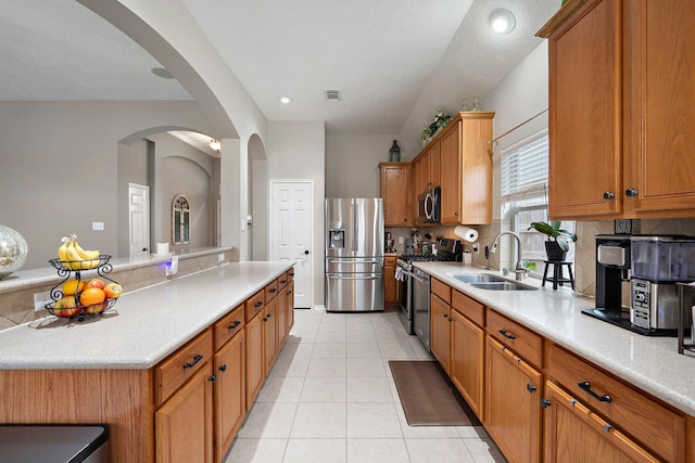 kitchen featuring sink, light tile patterned flooring, stainless steel appliances, and a kitchen island