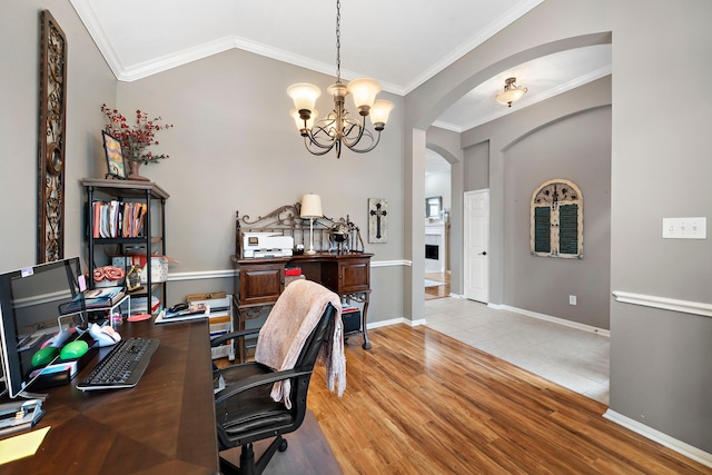 home office featuring lofted ceiling, ornamental molding, a notable chandelier, and light wood-type flooring