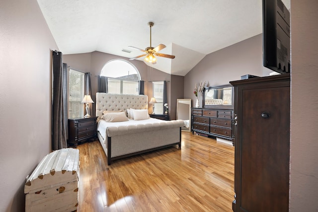 bedroom featuring lofted ceiling, light hardwood / wood-style flooring, and ceiling fan