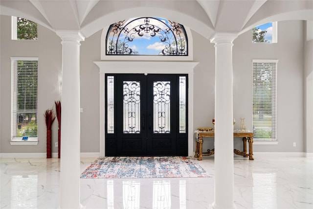 foyer with ornate columns and vaulted ceiling