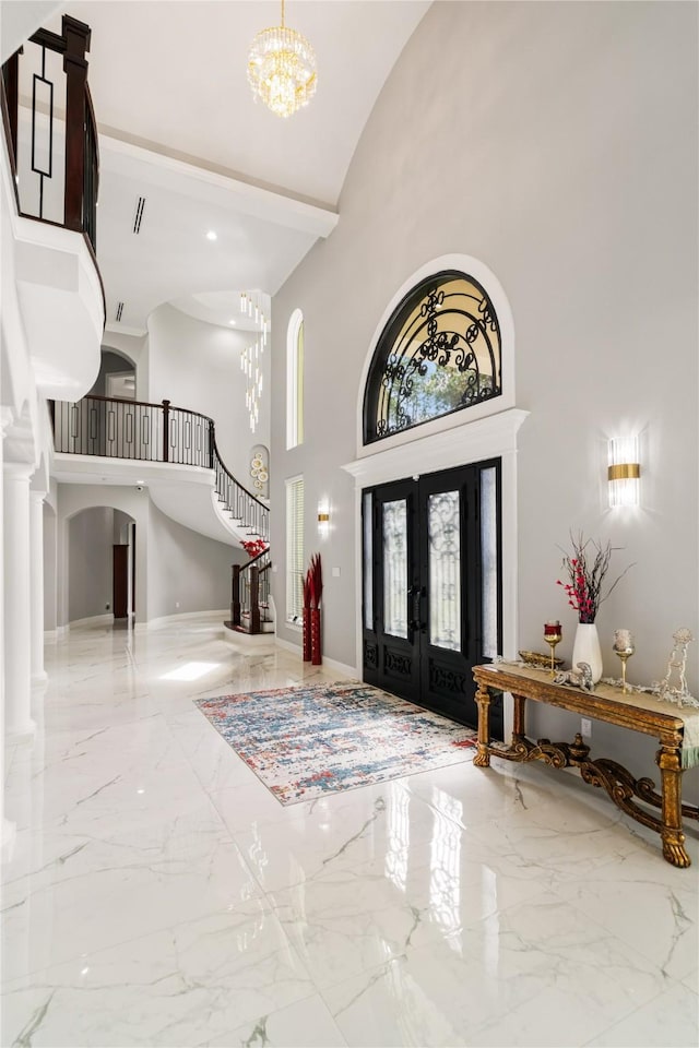 entryway with french doors, a chandelier, and a high ceiling