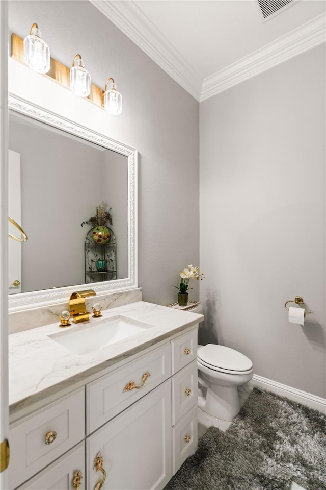 bathroom featuring vanity, ornamental molding, and toilet