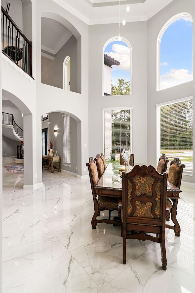 dining space with crown molding and plenty of natural light