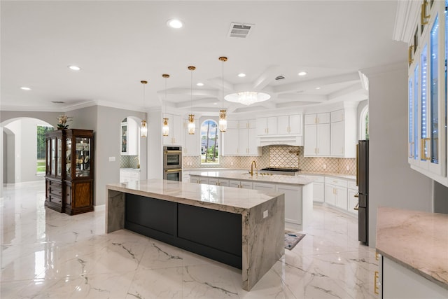 kitchen with white cabinetry, light stone countertops, a large island, and pendant lighting