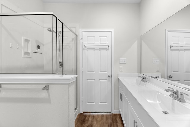 bathroom featuring walk in shower, wood-type flooring, and vanity