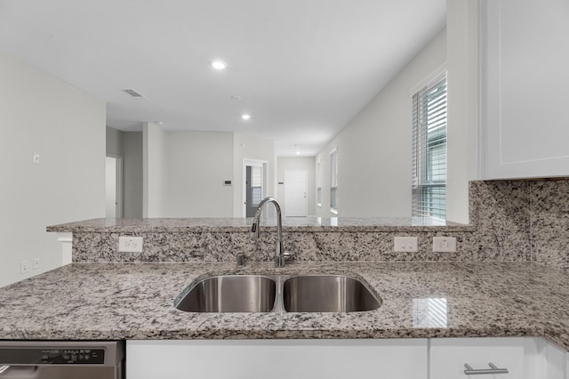 kitchen featuring white cabinetry, dishwasher, sink, and light stone countertops