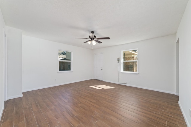 empty room featuring dark wood-type flooring and ceiling fan