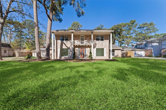 view of front of property with a balcony and a front yard