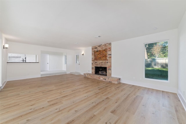 unfurnished living room with a fireplace and light hardwood / wood-style flooring