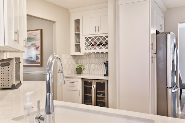 kitchen with wine cooler, stainless steel fridge with ice dispenser, decorative backsplash, and white cabinets