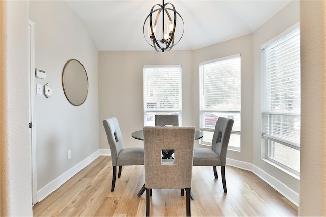 dining room featuring an inviting chandelier, a healthy amount of sunlight, and light hardwood / wood-style flooring