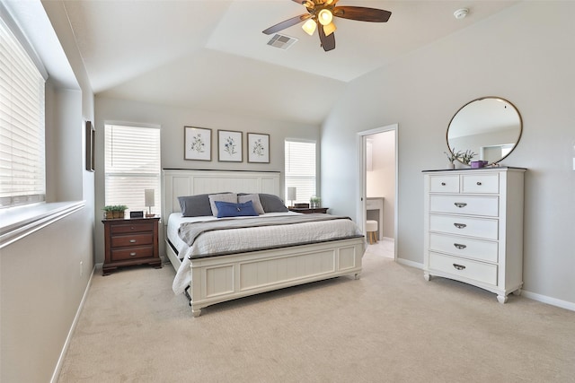 bedroom featuring multiple windows, lofted ceiling, and light carpet