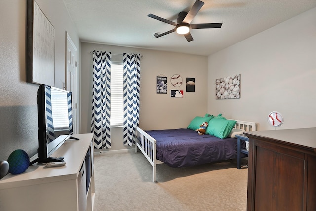 carpeted bedroom featuring multiple windows, a textured ceiling, and ceiling fan