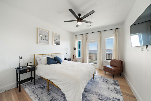 bedroom with access to exterior, light hardwood / wood-style flooring, and ceiling fan