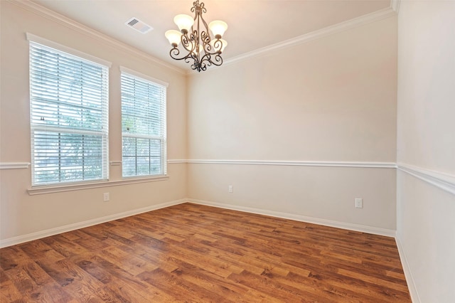 empty room featuring crown molding, dark hardwood / wood-style flooring, and a notable chandelier