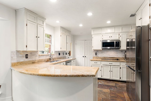 kitchen with white cabinetry, sink, backsplash, kitchen peninsula, and stainless steel appliances