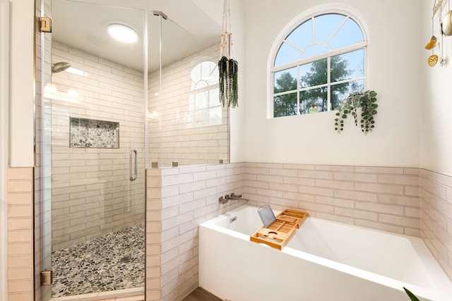 bathroom featuring separate shower and tub