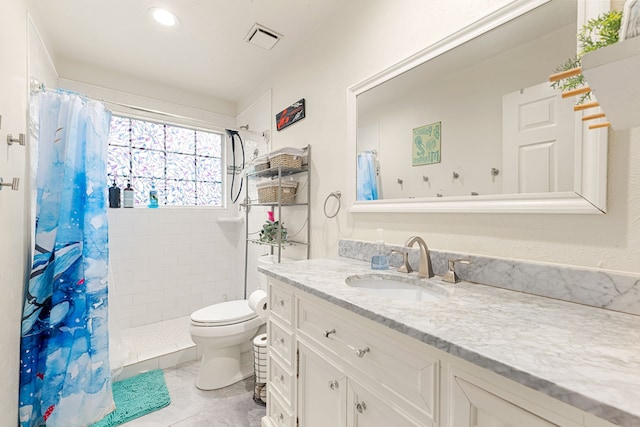 bathroom featuring tile patterned flooring, vanity, curtained shower, and toilet