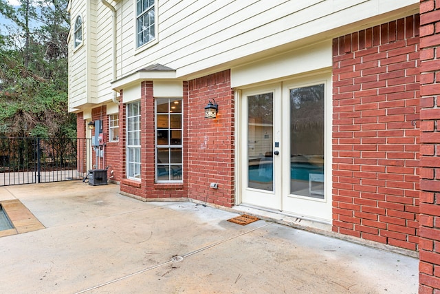 doorway to property with central AC unit and a patio area